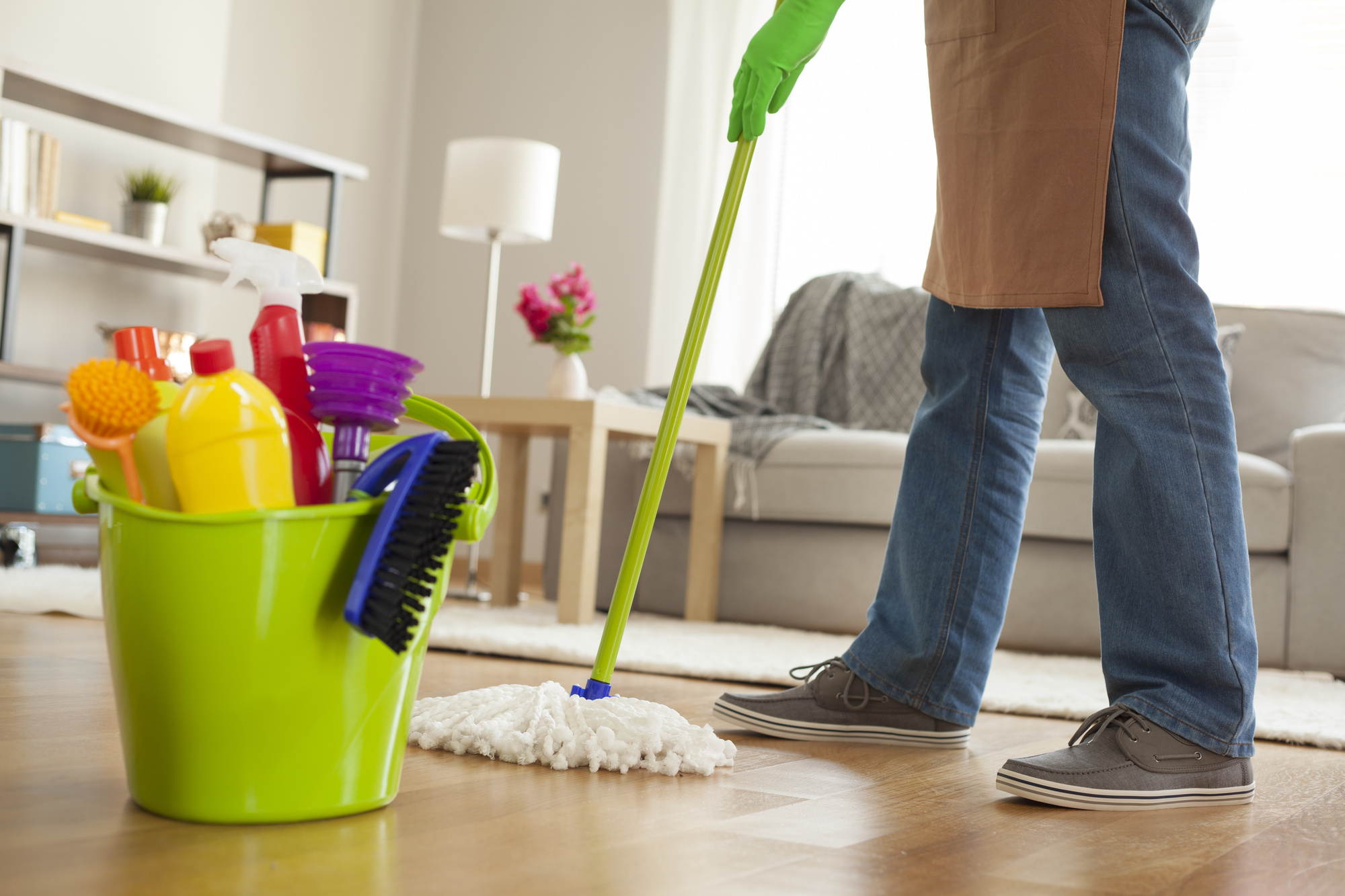 man holding mop and plastic bucket